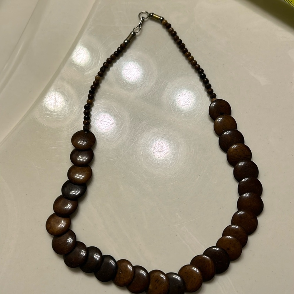 Woman’s brown beaded necklace.